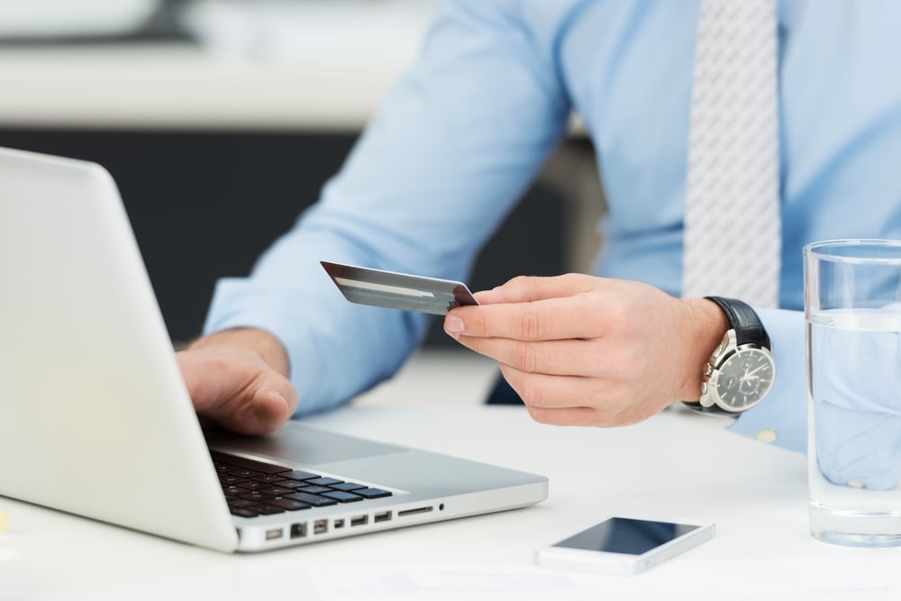 Businessman doing online banking, making a payment or purchasing goods on the internet entering his credit card details on a laptop, close up view of his hands-2