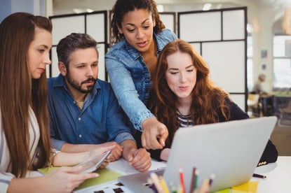 Businesswoman pointing at laptop with coworkers at desk in creative office-Apr-25-2024-11-16-36-6485-AM