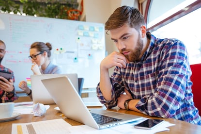 Concentrated bearded young man using laptop while his friends studying together-4