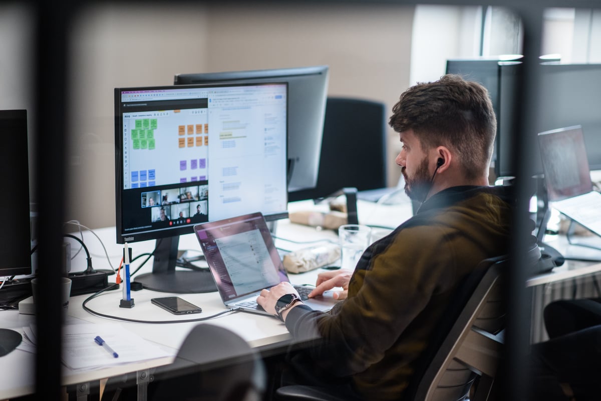 a man sitting at a desk, working on his laptop