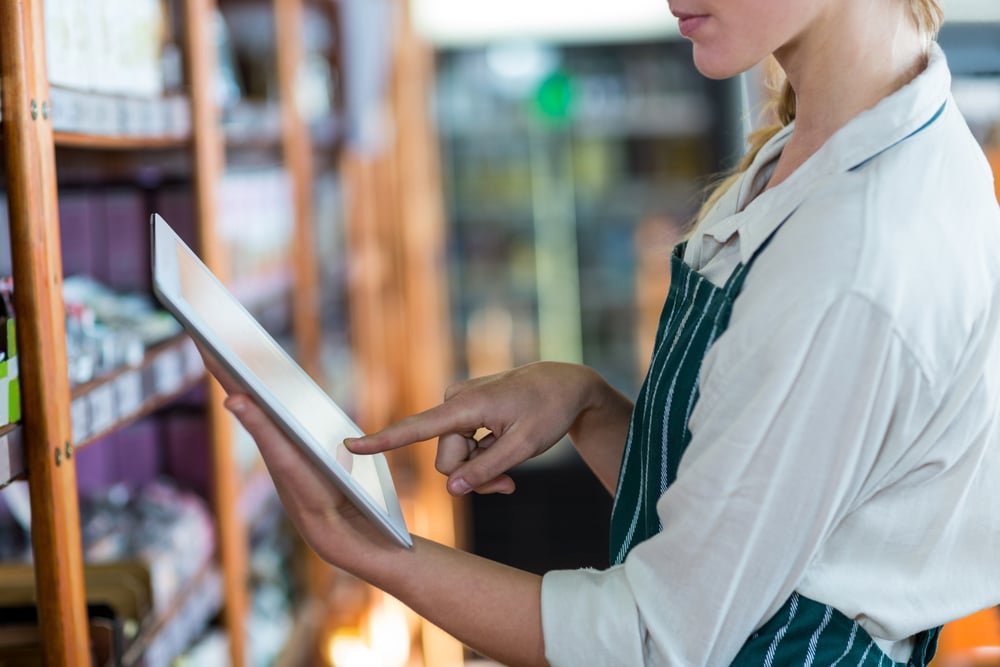 Mid-section of female staff using digital tablet in super market-2