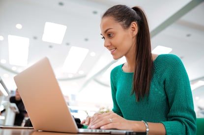 Portrait of a happy female student using laptop computer in university-3