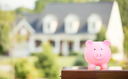 Real estate sale, home savings, loans market concept. Housing industry mortgage plan and residential tax saving strategy. Piggy bank isolated outside home on background. Focus on piggybank. Homeowner-1