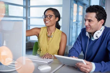 Two  colleages discussing ideas using a tablet and computer-1