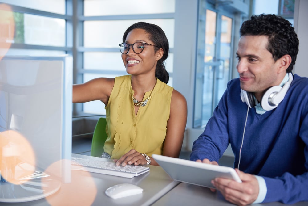 Two  colleages discussing ideas using a tablet and computer-1