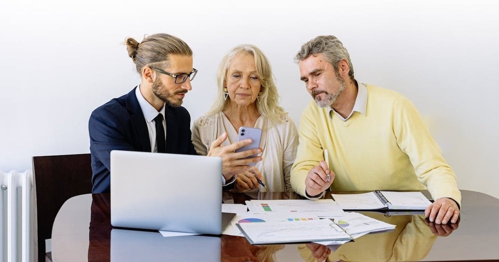 isurance agent with clients and laptop