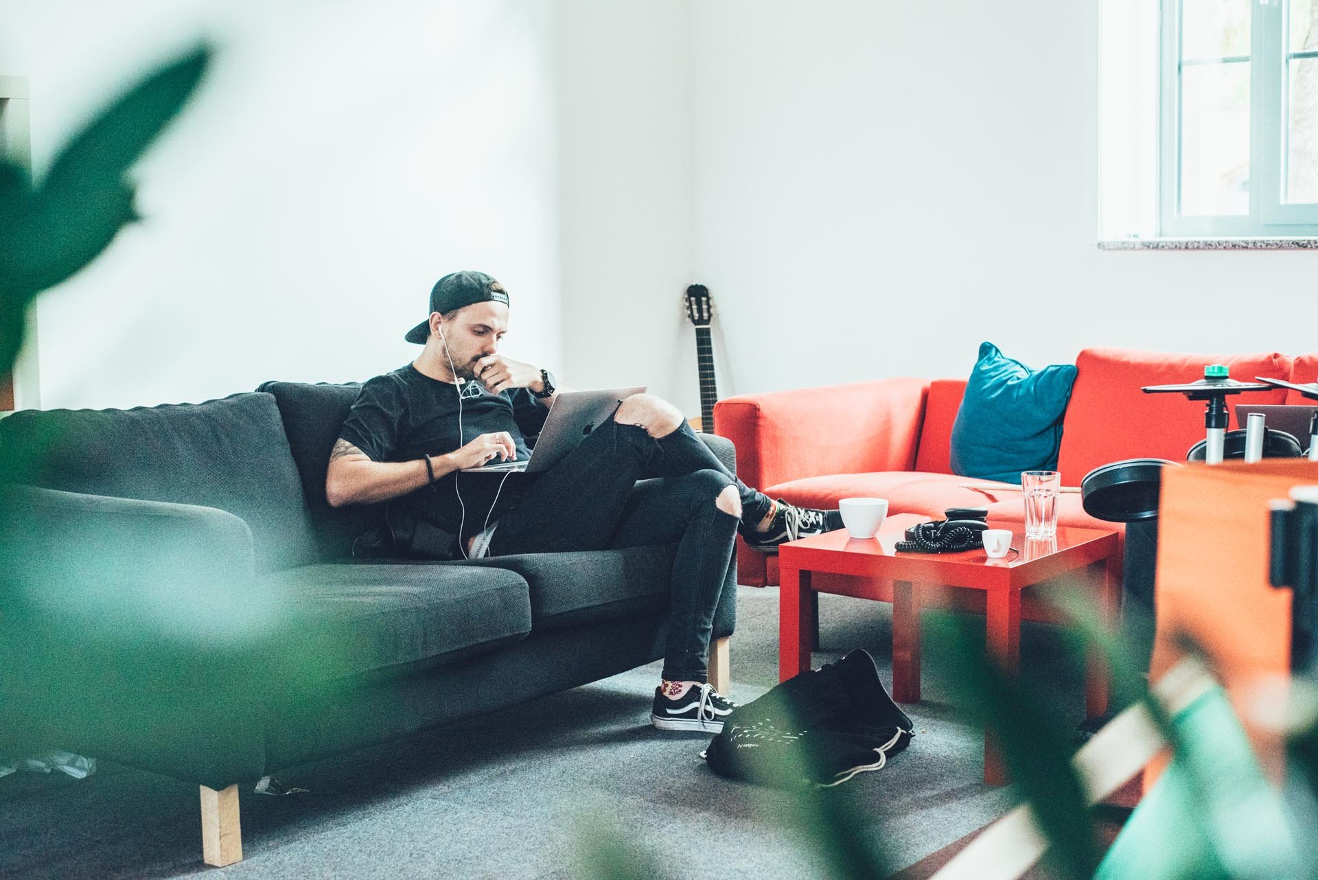 man working on his laptop sitting on a sofa in the office 