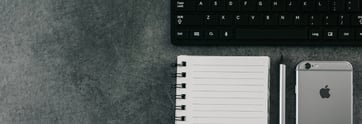 kaboompics.com_Top view of office desk table with open spiral notebook, pencil, iPhone 6, and black keyboard 3-398869-edited.jpg