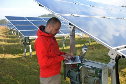 business man  engineer using laptop at solar panels plant eco energy field  in background