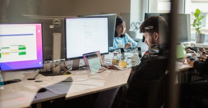 designer at the office with a laptop and computer screens