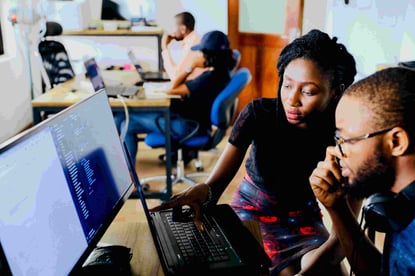 Design team, man and woman, looking at a laptop screen