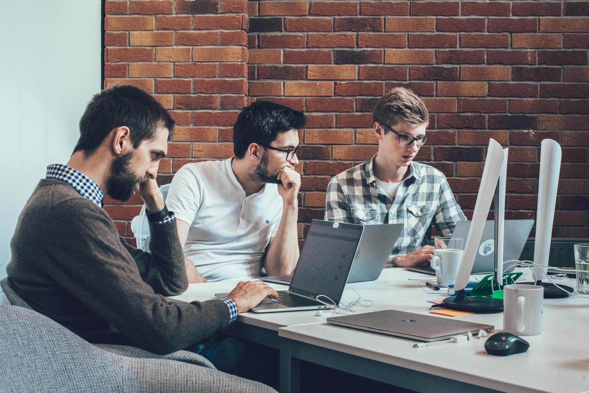 men sitting at at table working