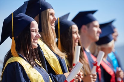 young graduates students group  standing in front of university building on graduation day