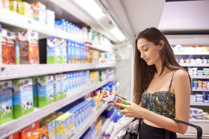 young woman shopping for fruits and vegetables in produce department of a grocery store supermarket